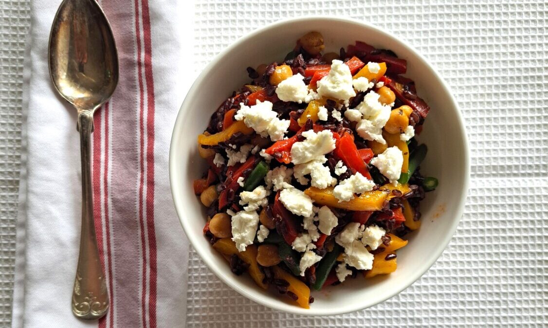 Riso venere con fagiolini, peperoni rossi e gialli, feta, prezzemolo e ceci al curry